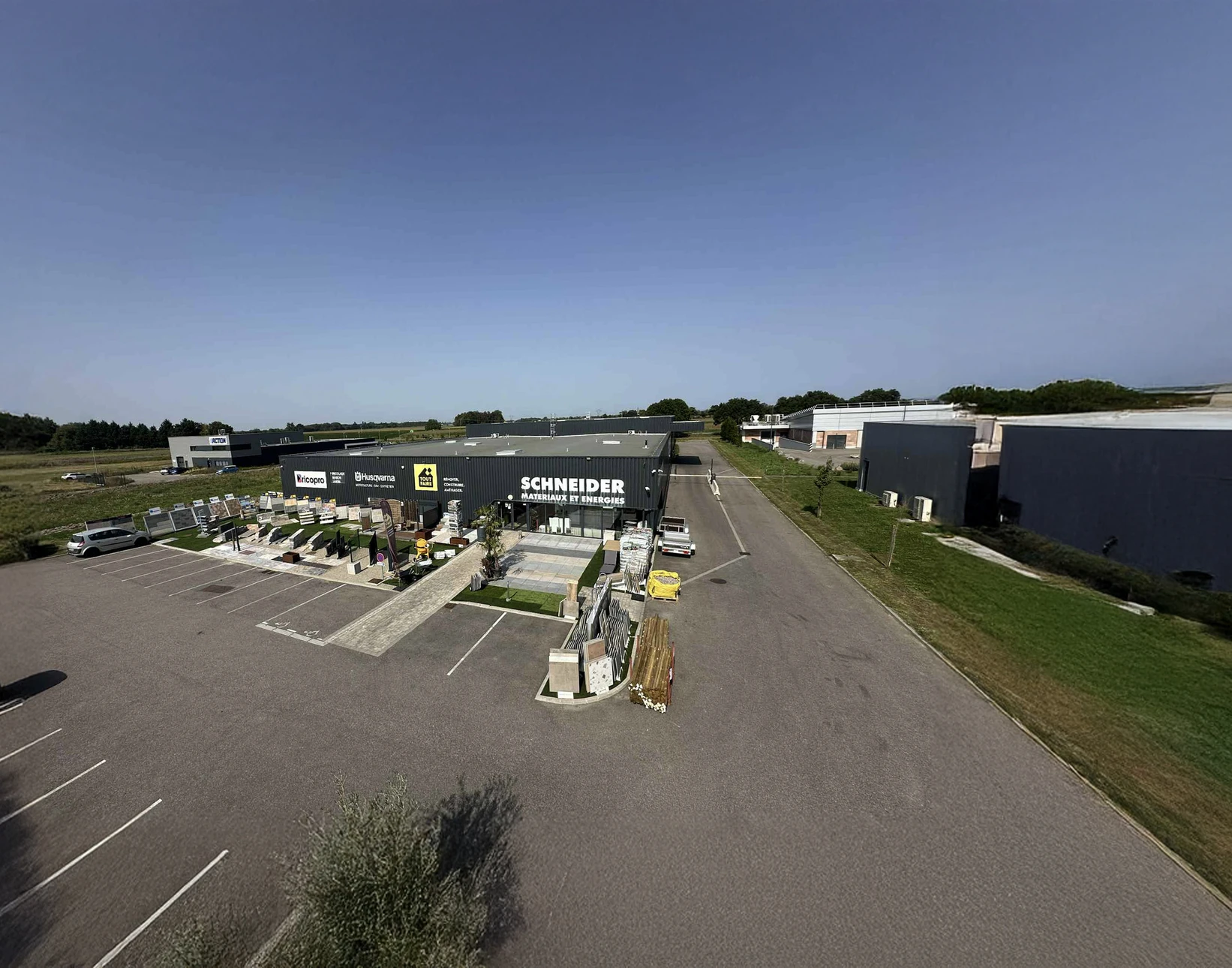 Vue aérienne d'un complexe commercial de matériaux de construction avec magasin Schneider au centre