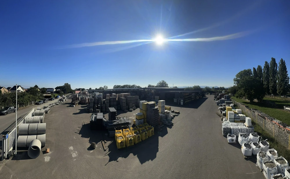 Chantier de construction résidentielle avec camion-grue jaune Schneider livrant des matériaux