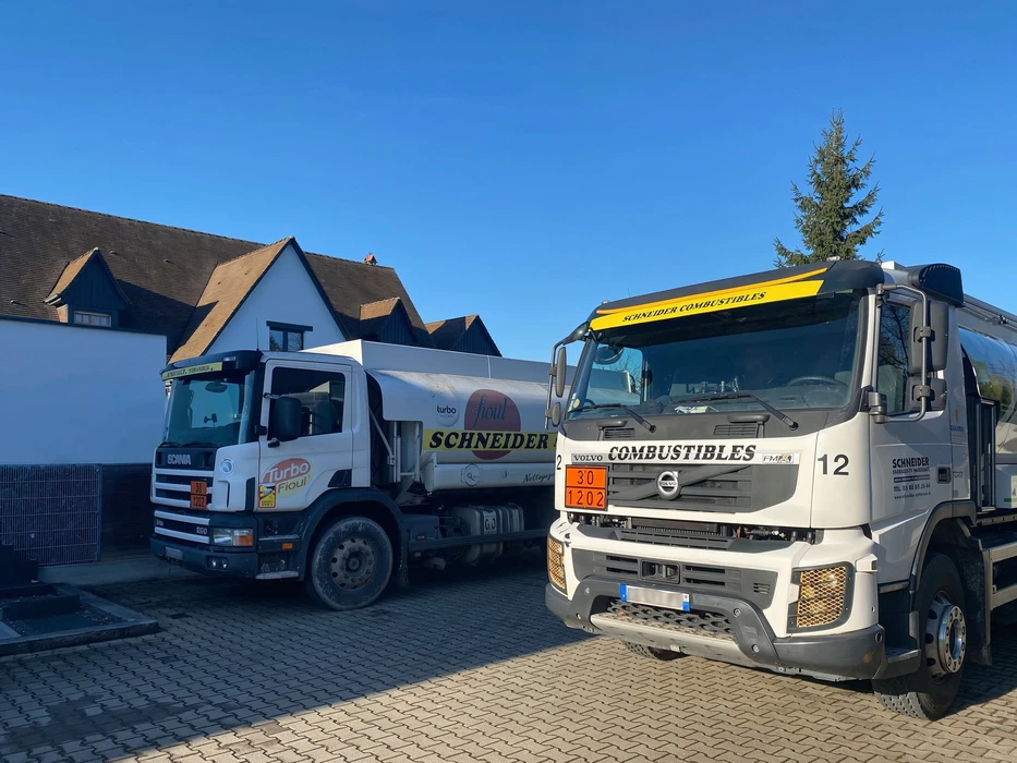 Chantier de construction extérieur avec ouvrier opérant une grue mobile télescopique jaune près d'une structure en maçonnerie de briques rouges en cours d'édification