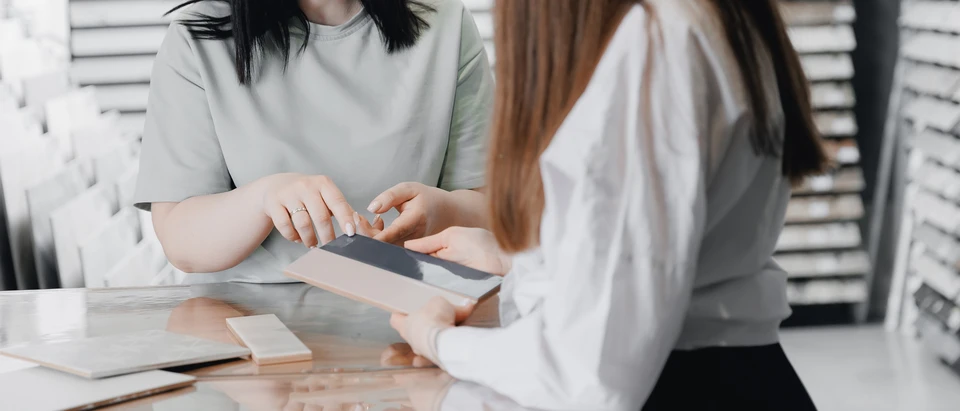 Main feminine touchant échantillons de revêtements de sol dans showroom professionnel