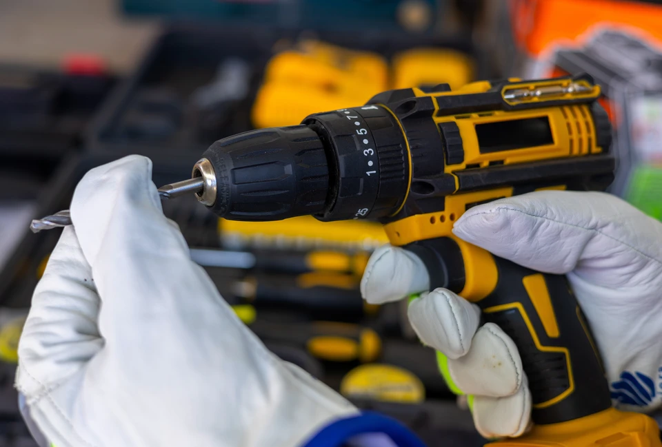 Atelier de réparation intérieur avec mécanicien démontant une tronçonneuse rouge