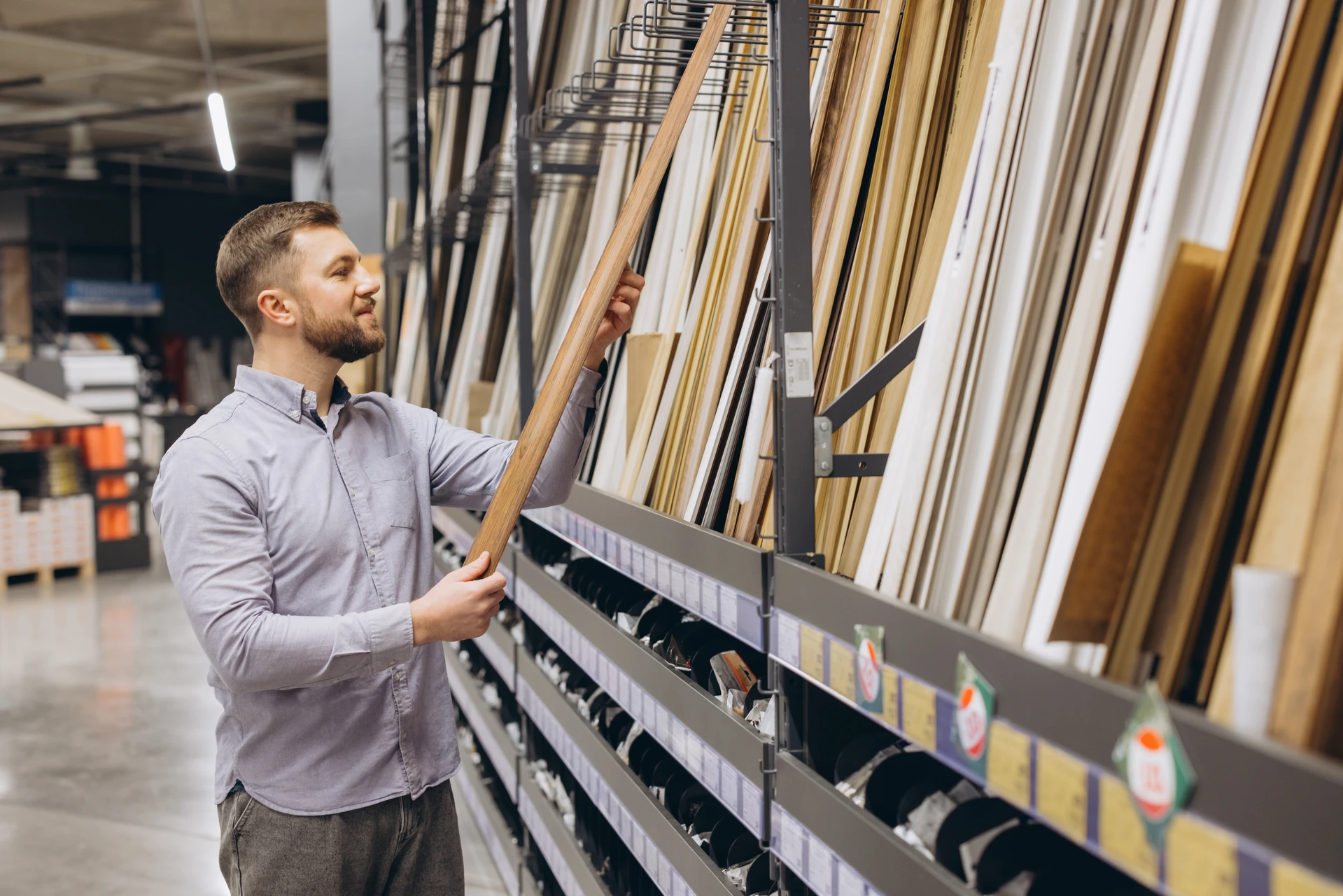 Deux livreurs en uniformes bleus et masques sanitaires portent des colis cartonnés devant un camion de livraison blanc aux portes arrière ouvertes, sous un ciel nuageux en extérieur